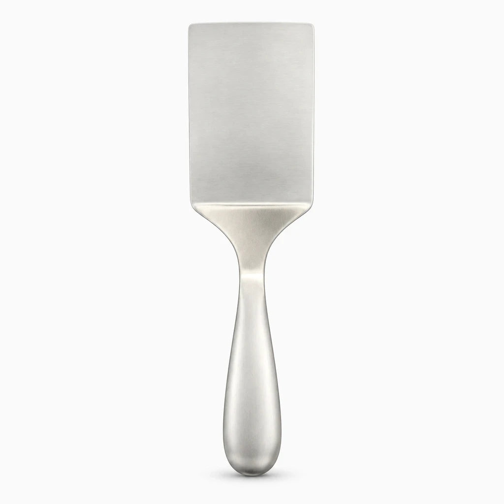 Lame fine de spatule inox glissant sous crêpe sur poêle antiadhésive