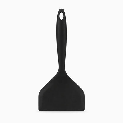 Tête souple de spatule silicone épousant le fond d'une poêle antiadhésive