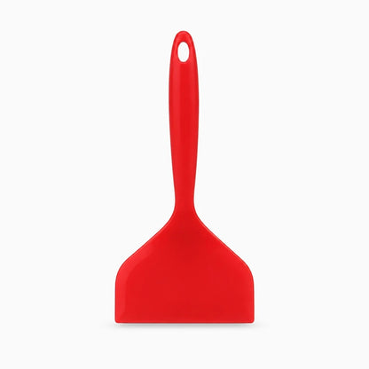 Spatule cuisine en silicone flexible se glissant sous une crêpe dorée
